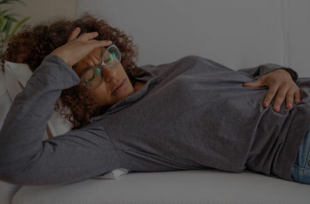 Sick woman holding her belly and her head